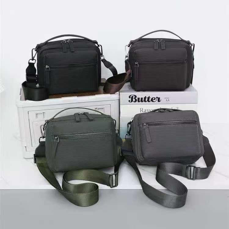 Four utility crossbody bags with zippers in black, brown, olive green and gray colors.