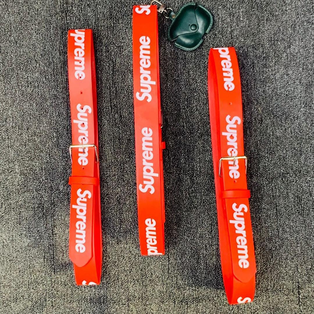 Red Supreme logo belts with buckles and green case.