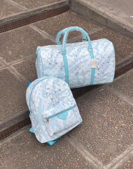 Light blue teddy print backpack and duffle bag set on outdoor steps.