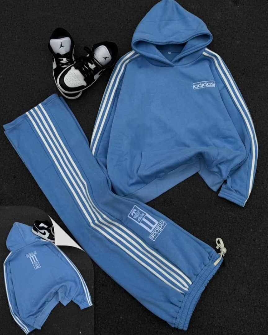 Blue Adidas hoodie and matching joggers with white stripes in product photography.