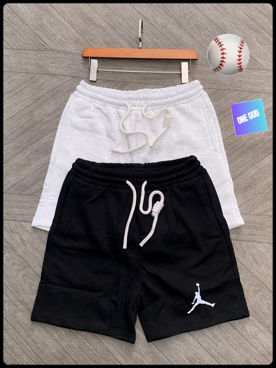 Black fleece shorts with white Jumpman logo and white pair displayed.