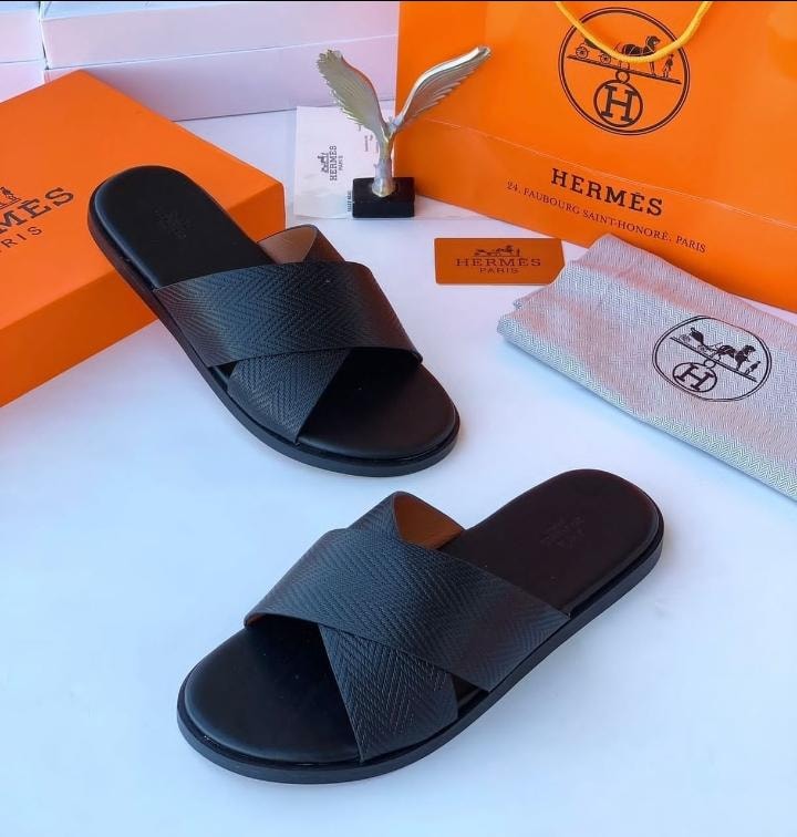 Hermes black criss-cross textured slide sandals with orange boxes and dust bag.