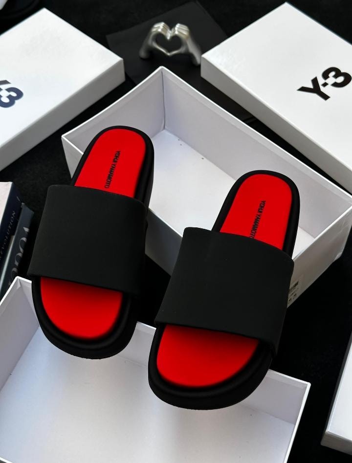Black Y-3 platform slides with bright red insole shown in open white box.