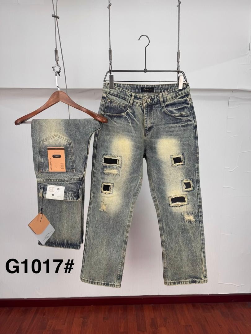 Light blue acid wash jeans with multiple square rips and folded pair on hanger.