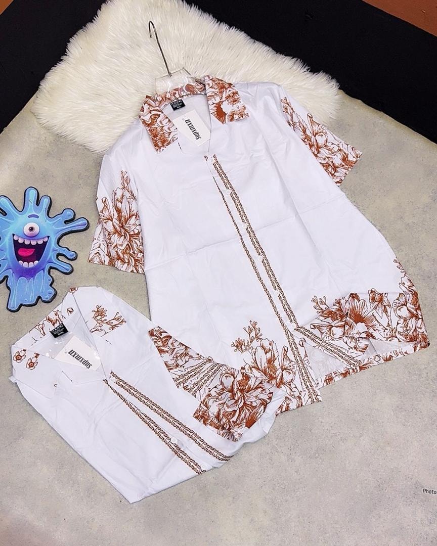 White short sleeve shirt with brown floral prints and linear border details.