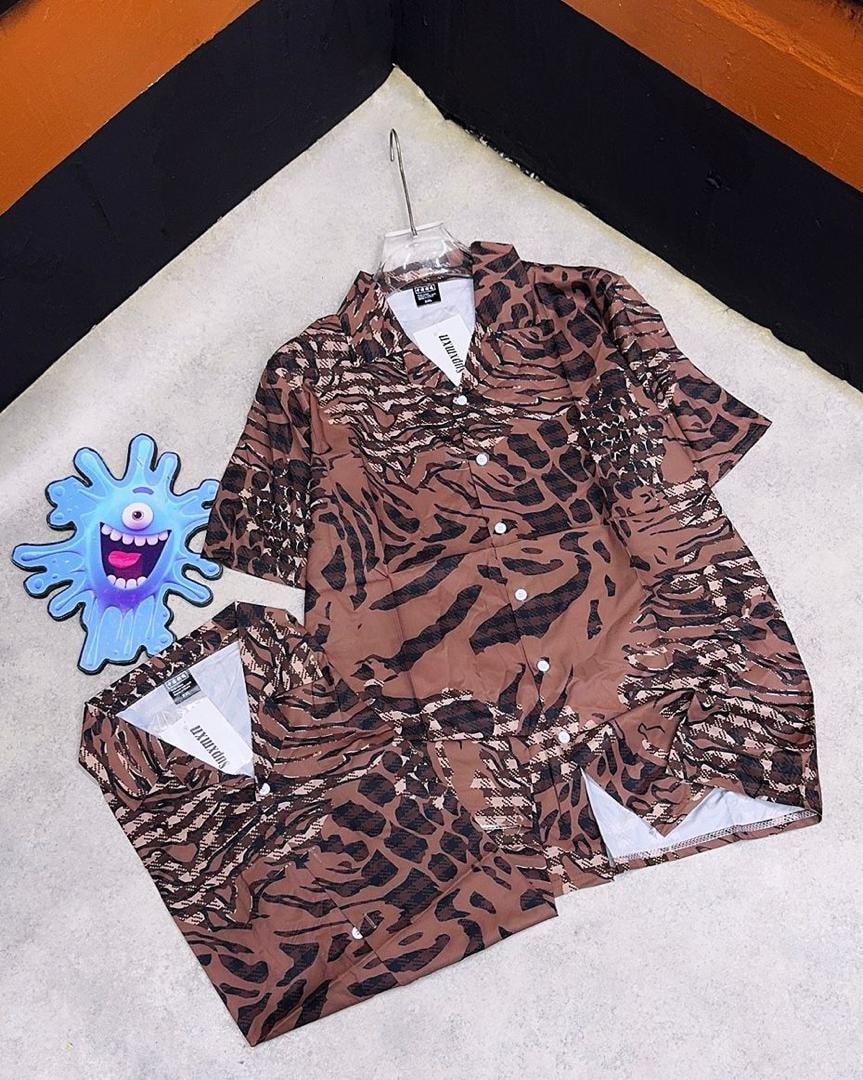 Brown short sleeve shirt with black animal print pattern, shown hanging and flat.