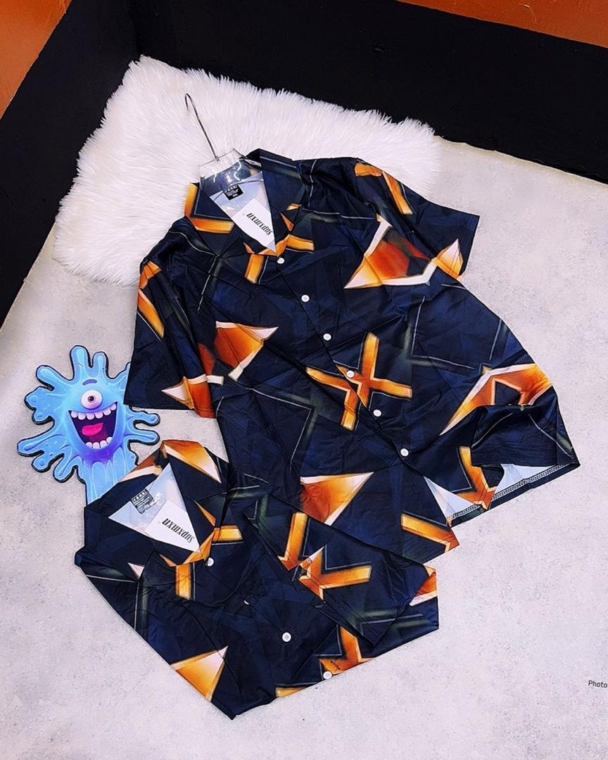 Navy short sleeve shirt with orange and white geometric patterns, displayed on hanger and flat lay.