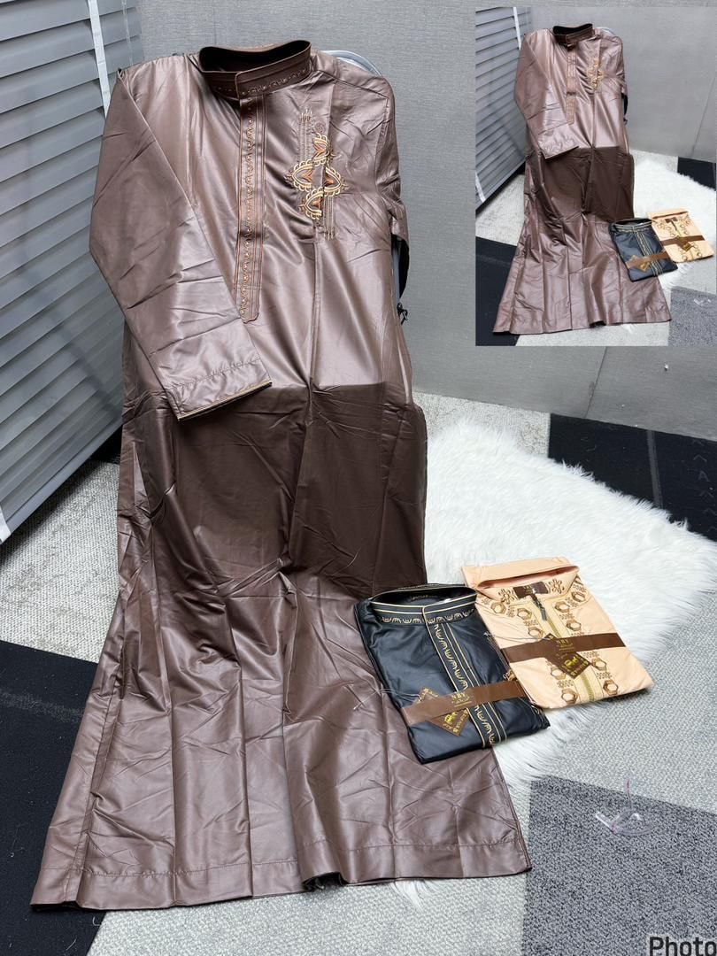 Shiny brown men's jalabia with gold embroidery displayed with black and beige folded options.