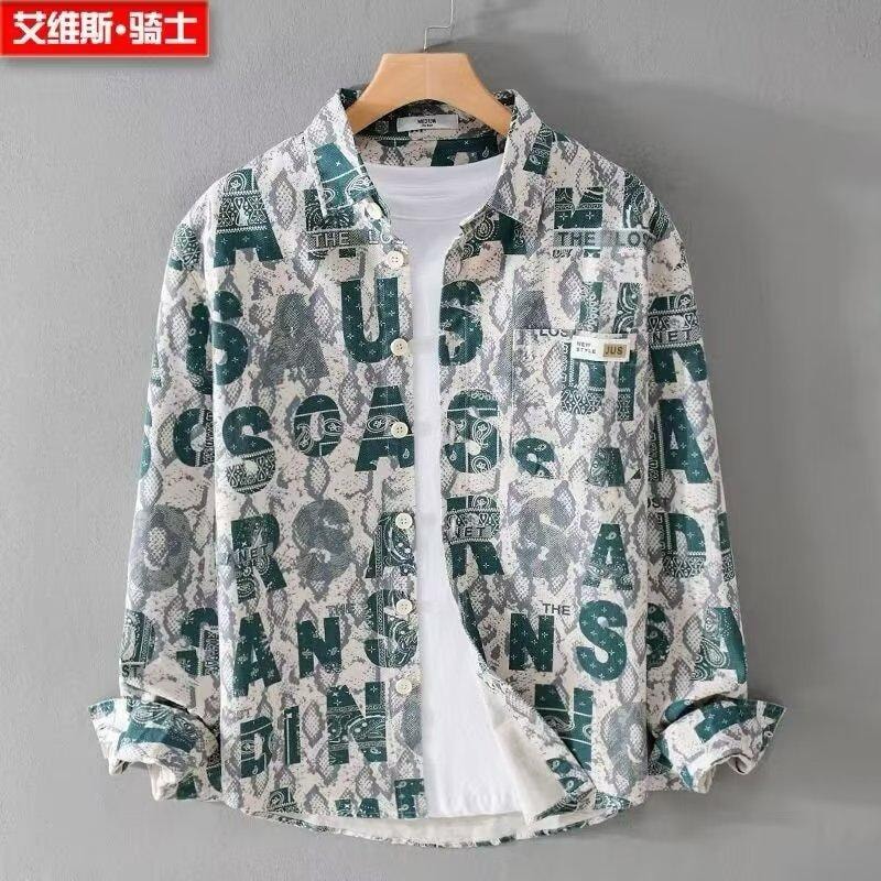 Green snake skin and text pattern long sleeve shirt hanging open over white tee.