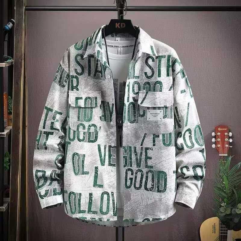 White shirt with green distressed all-over typography print on hanger.