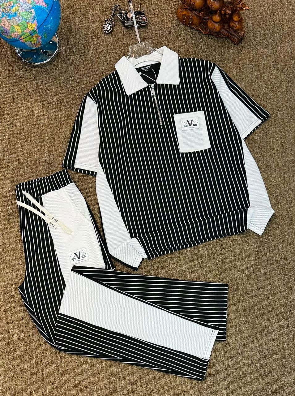 Black and white striped ribbed polo and jogger two-piece set laid flat.