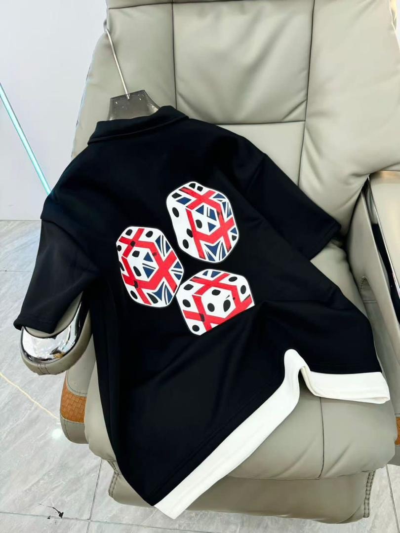 Black polo shirt with dice and Union Jack graphics on the back, displayed on a chair.