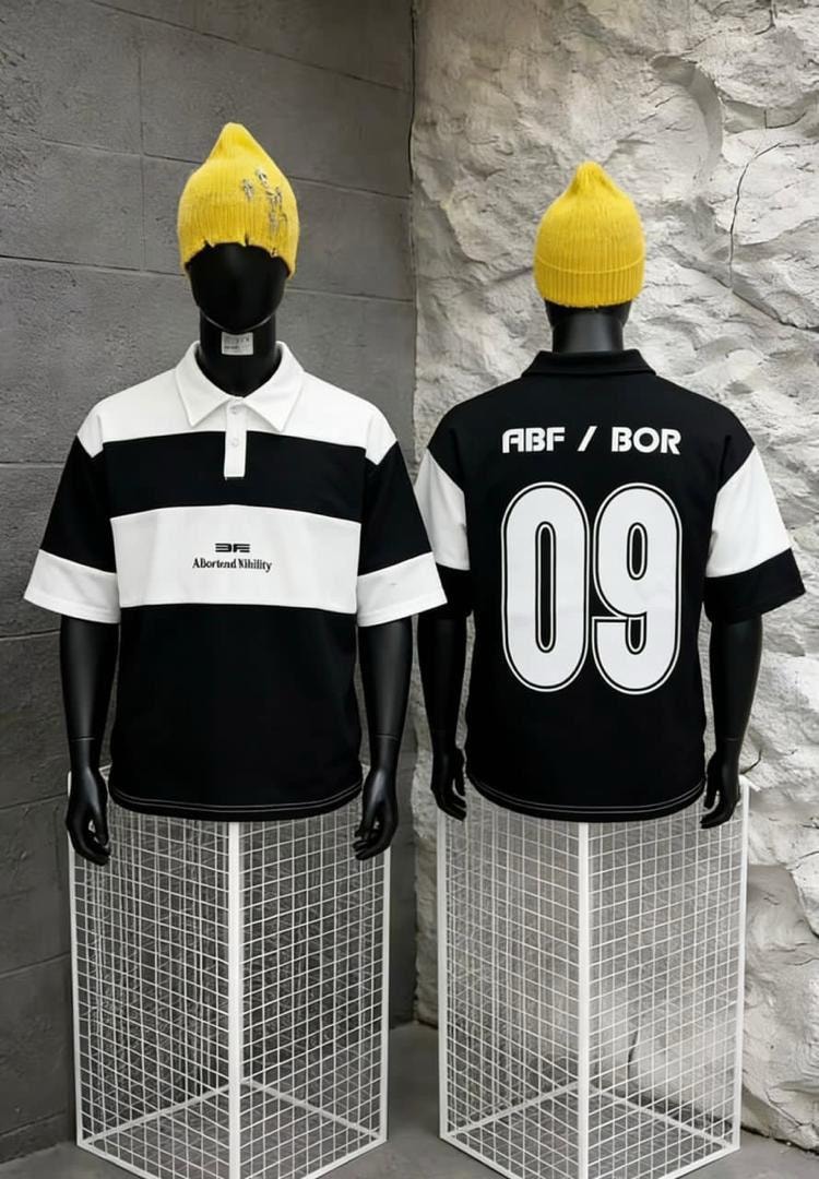 Front and back views of black and white striped polo shirt on mannequins wearing yellow beanies.