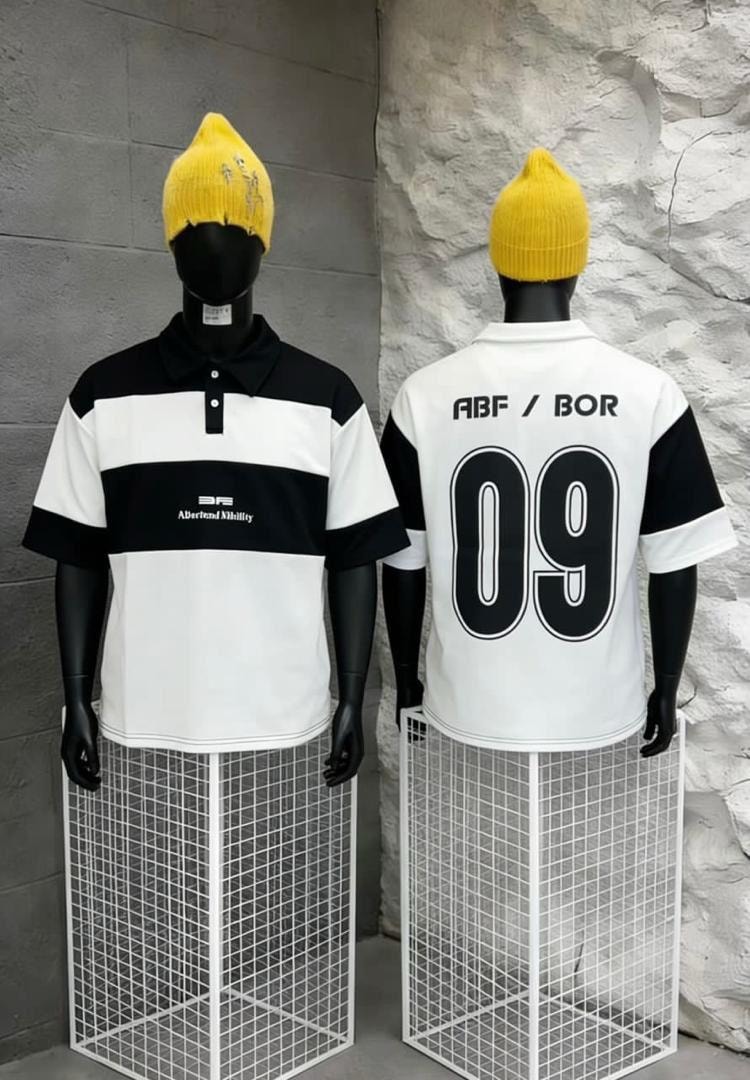 Front and back views of white and black striped polo shirt on mannequins wearing yellow beanies.