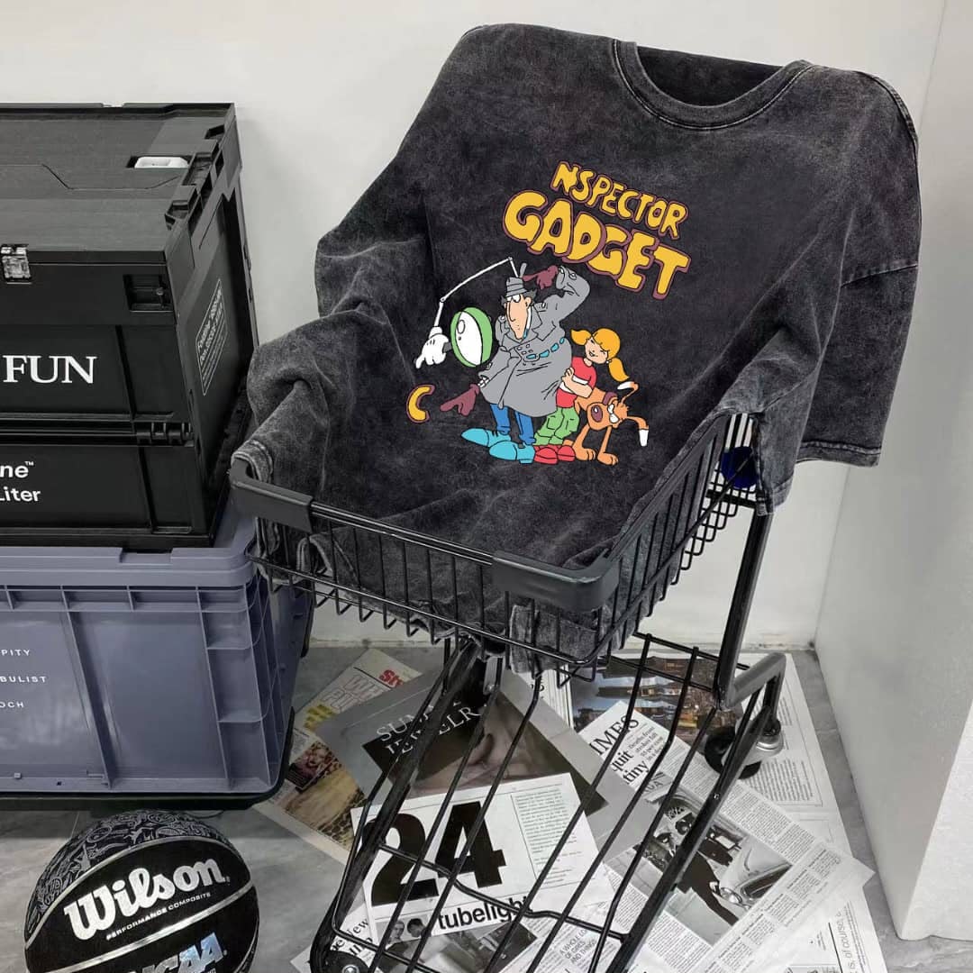 Dark washed t-shirt with Inspector Gadget cartoon print, placed in a black shopping basket.