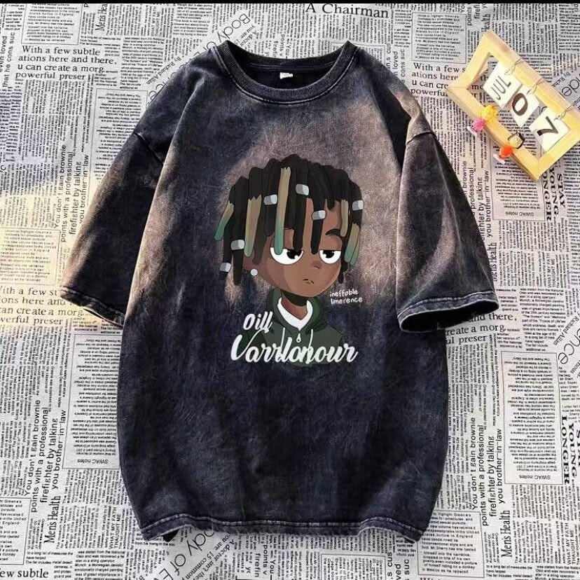 Oversized dark washed t-shirt with cartoon character print and text, displayed on newspaper background.