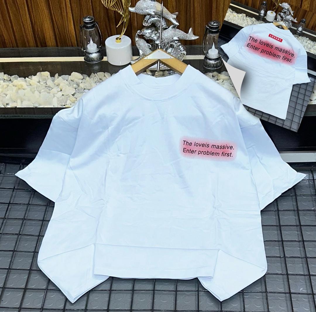 White oversized t-shirt on hanger with red gradient chest print 'The loveis massive. Enter problem first.'