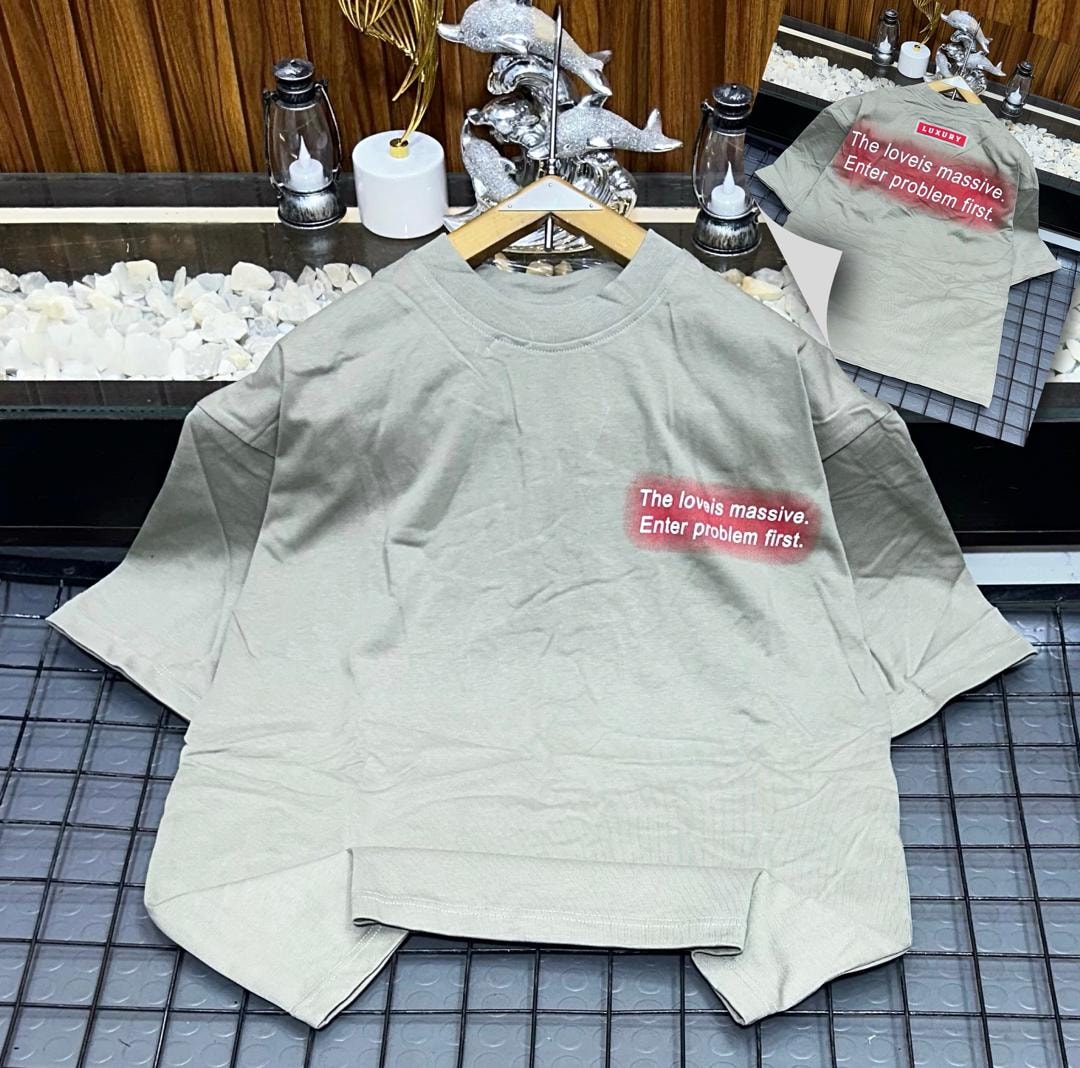 Beige oversized t-shirt on hanger with red gradient chest print 'The loveis massive. Enter problem first.'