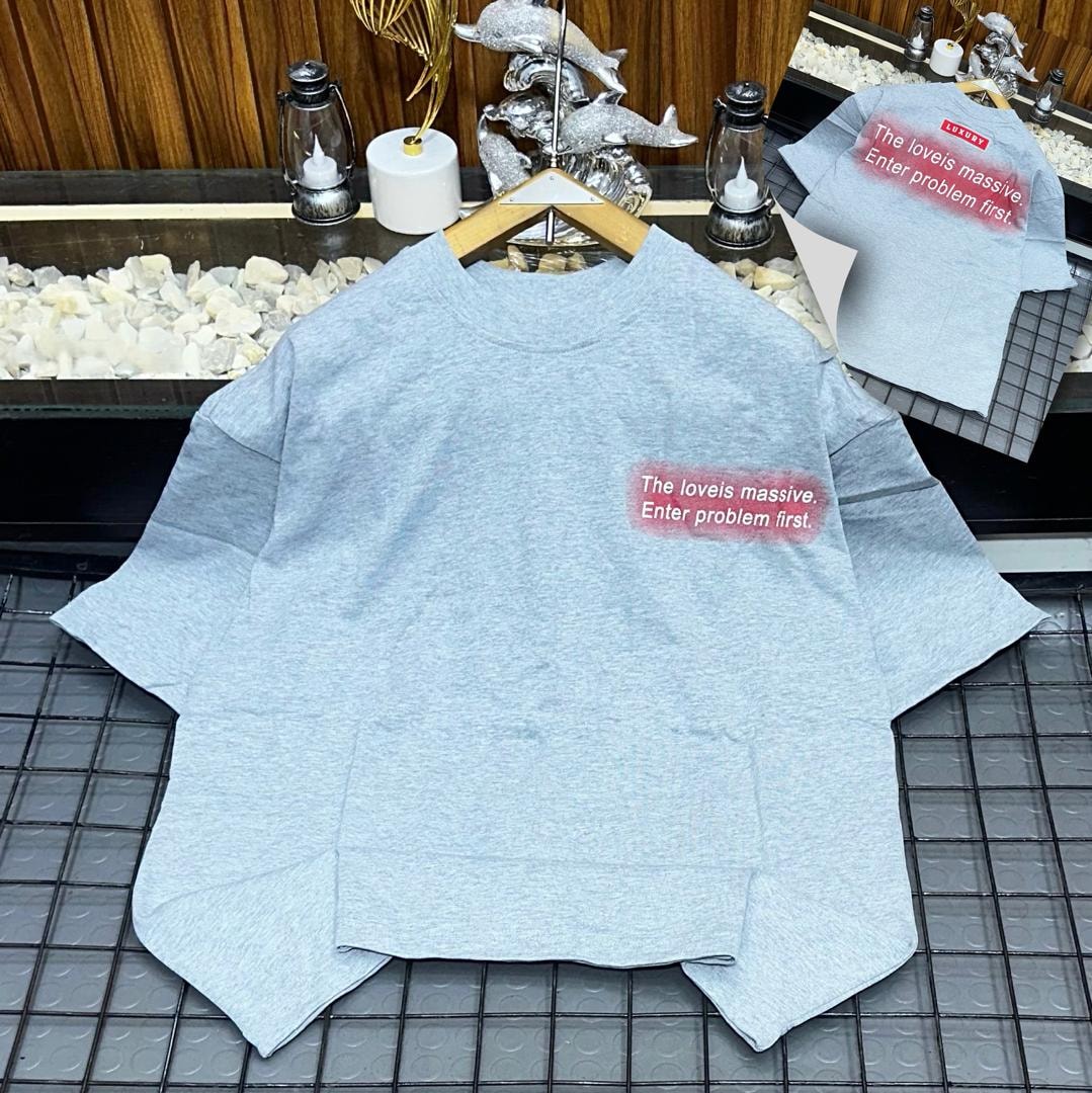 Light blue oversized t-shirt on hanger with red gradient chest print 'The loveis massive. Enter problem first.'