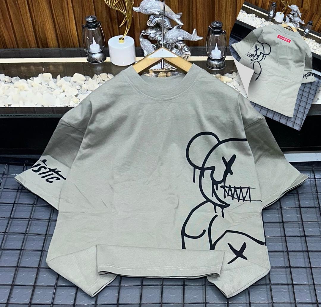 Olive oversized t-shirt with black abstract figure graphic on front and sleeve.