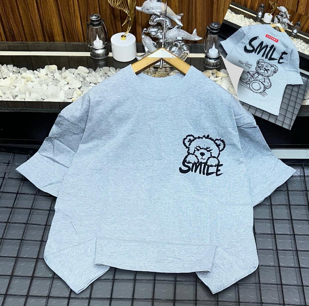 Light blue oversized t-shirt with black bear and SMILE graphic on chest, back view inset.