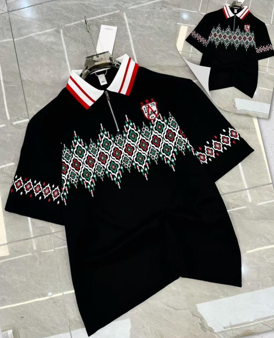Black polo shirt with geometric embroidery, striped collar and half-zip neck.