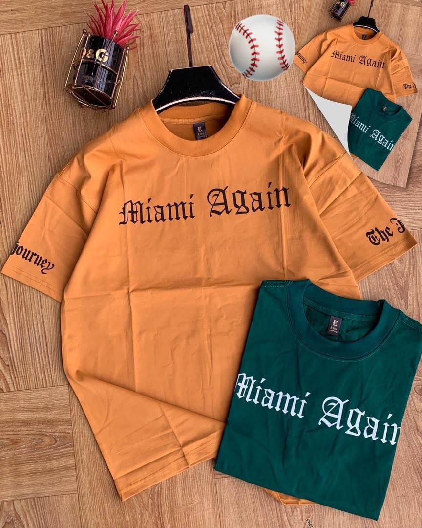 Orange and green Miami Again t-shirts with baseball prop.