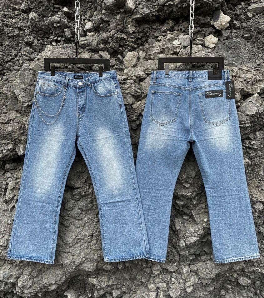 Two light blue jeans shown from back, one with silver chain on pocket and one with logo tag.