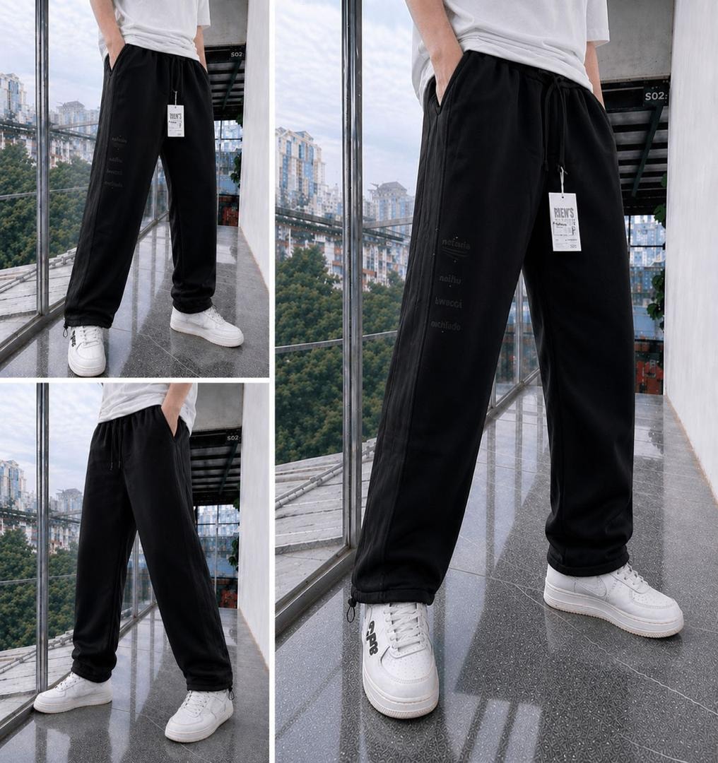 Black joggers with vertical side text print shown in multiple angles on a model with white t-shirt and sneakers.