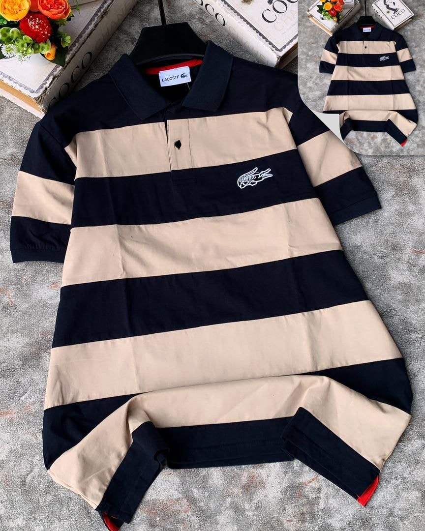 Lacoste striped polo shirt in navy and beige laid flat on textured surface.