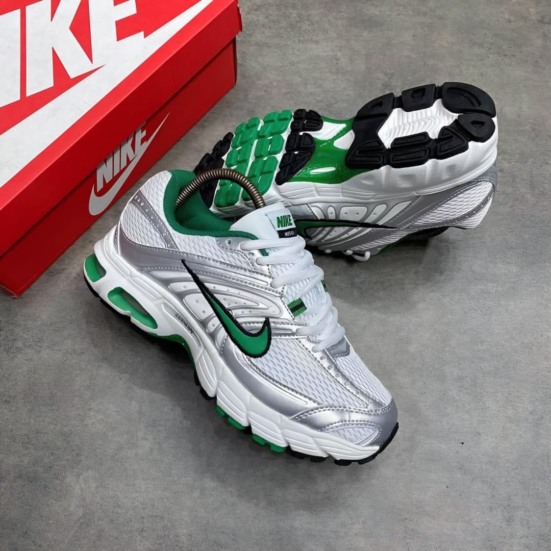 White silver and green Nike Air Max sneakers with red Nike box in background.