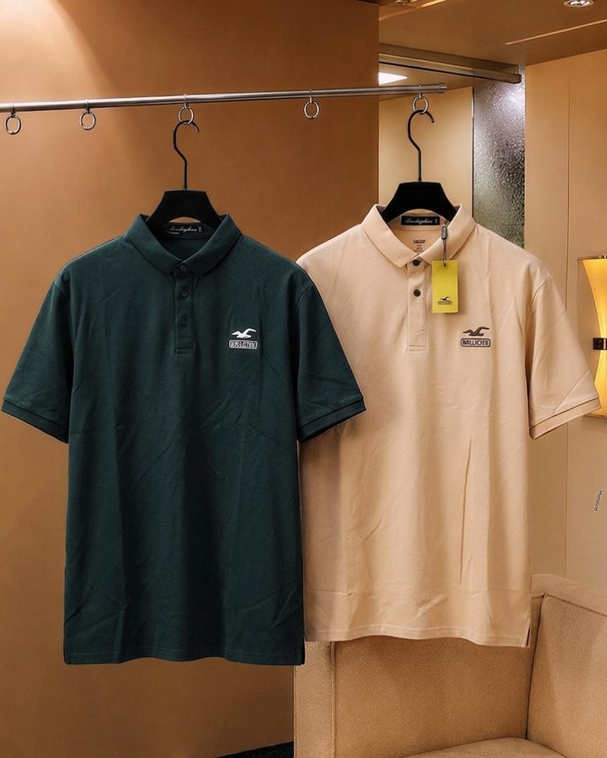 Dark green and beige Hollister polo shirts hanging side by side.