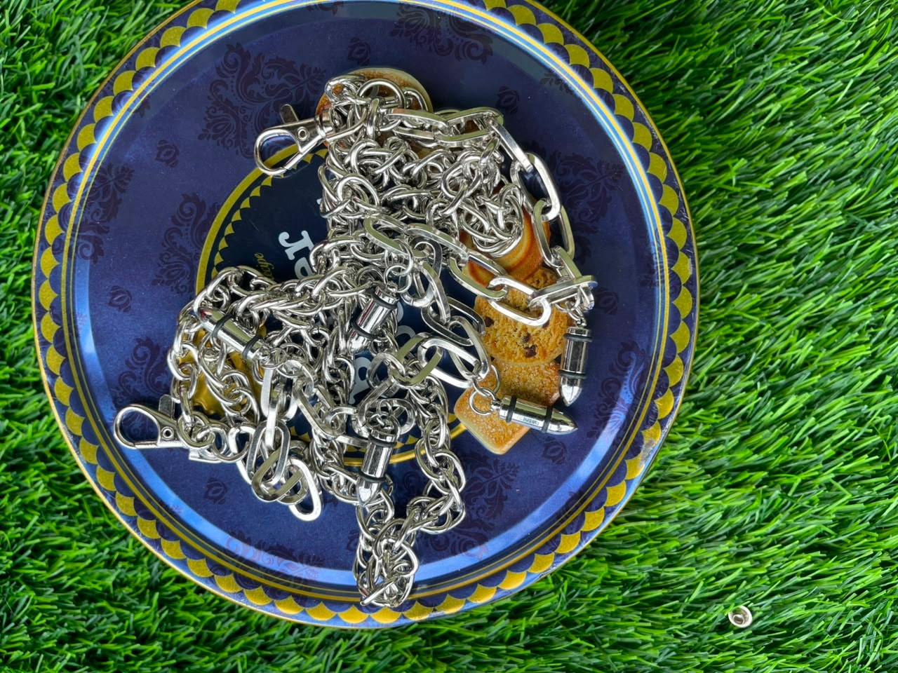 Assorted silver jean chains with bullet charms and metal hardware.