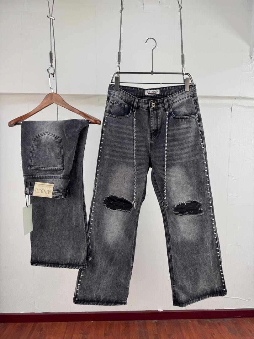 Dark wash baggy jeans with knee rips, side studs and hanging silver chain.