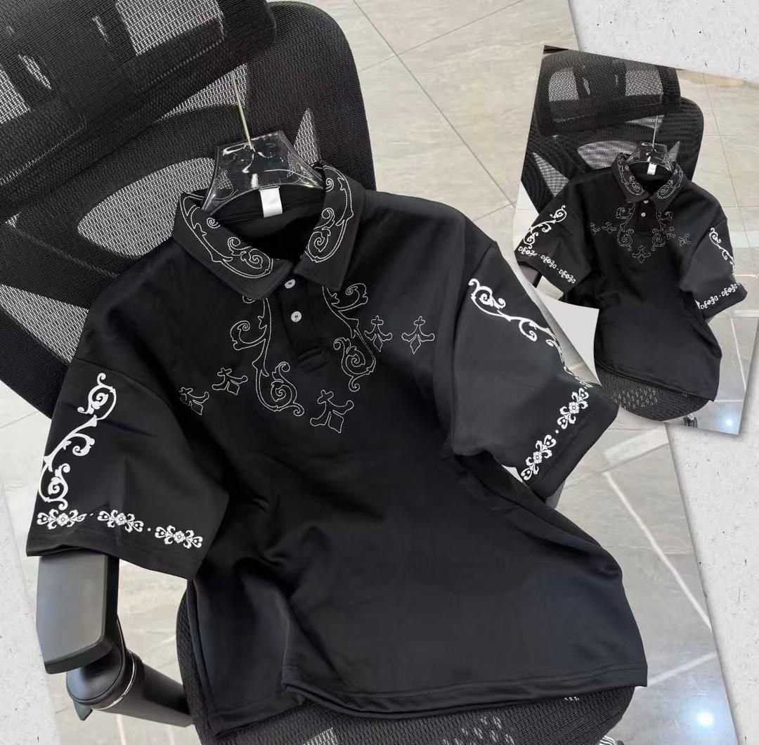 Black polo shirt with white ornate embroidery on chest, sleeves and collar.