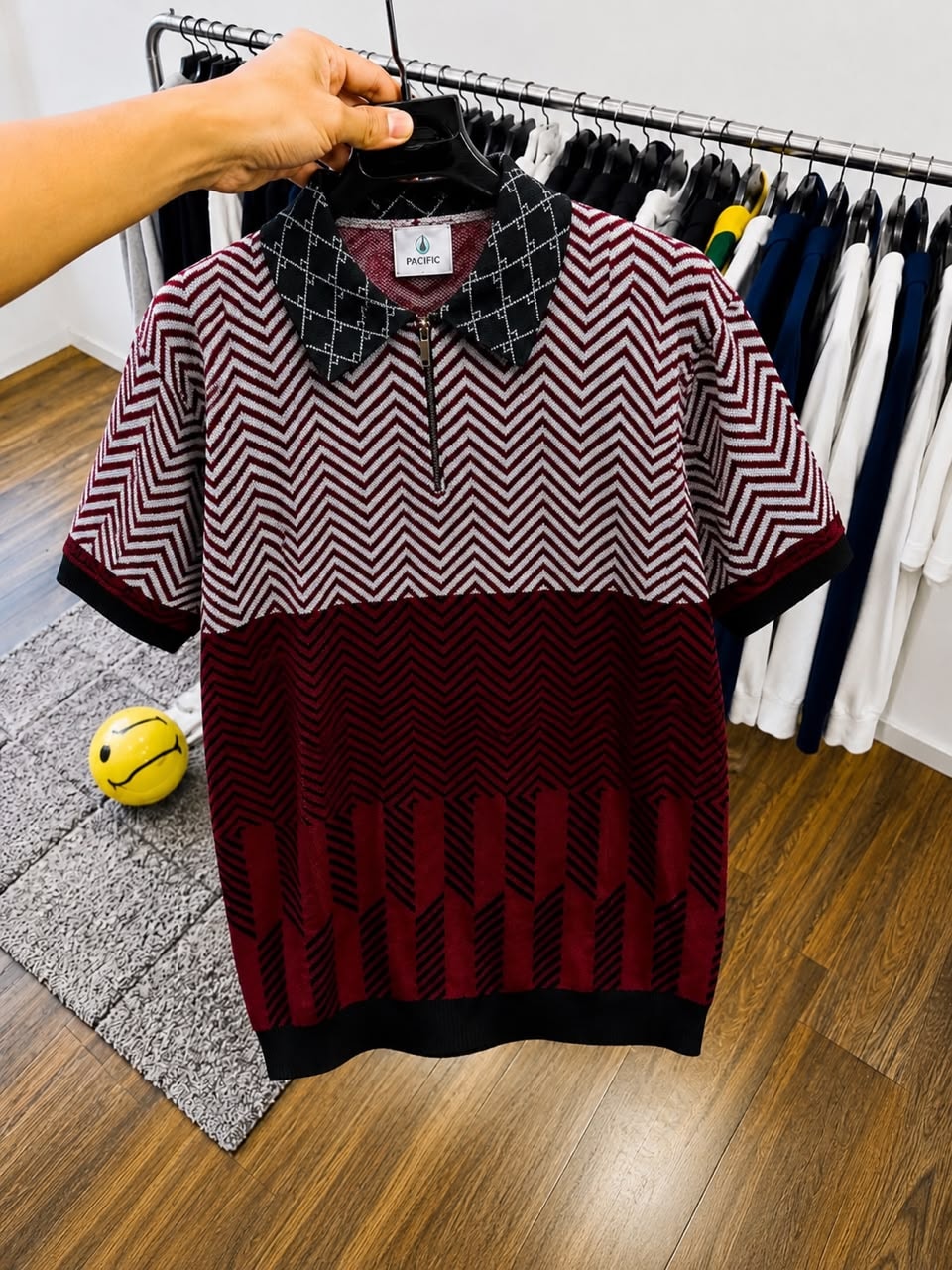 Maroon and black chevron polo shirt on hanger.