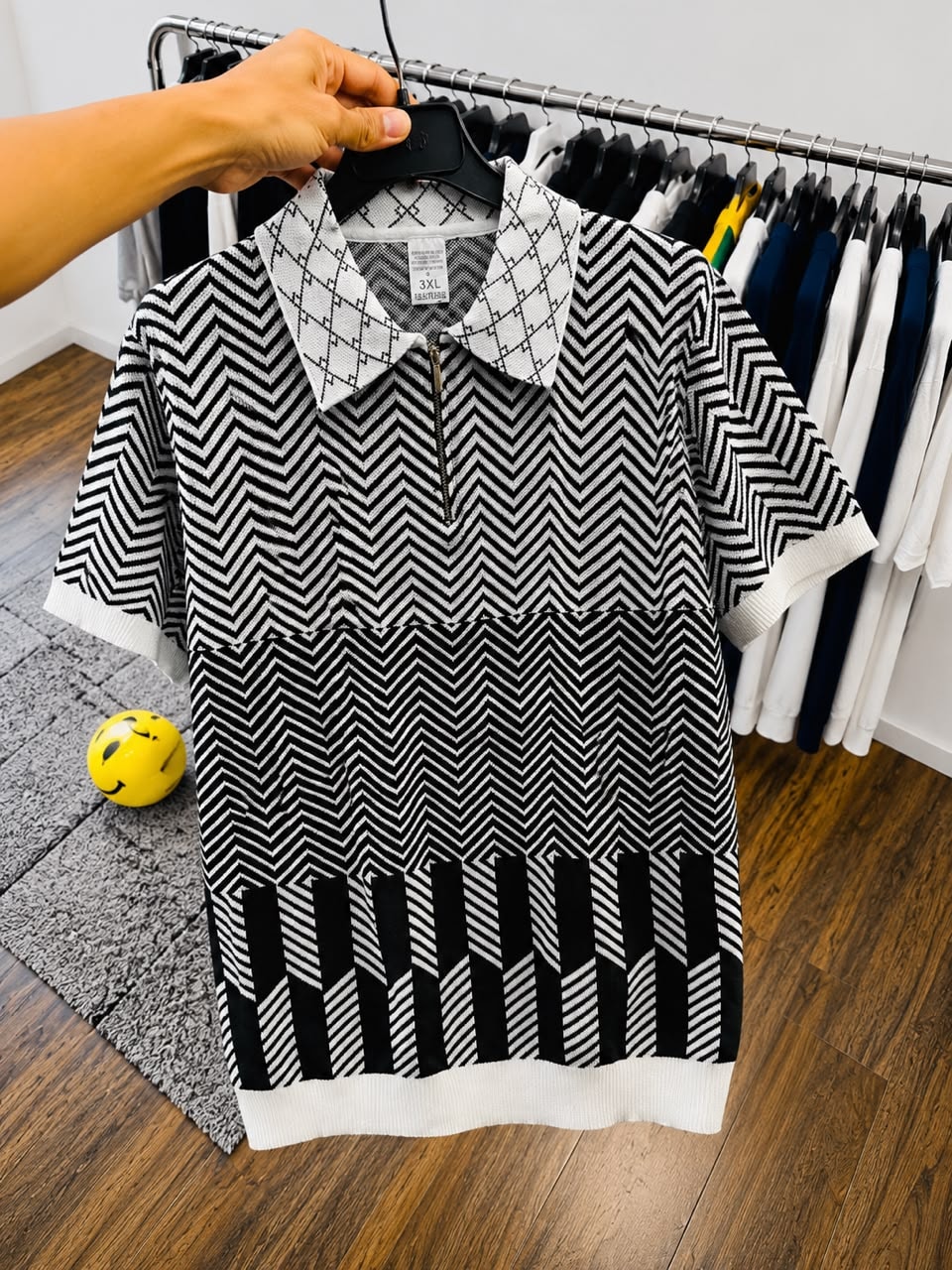 Black and white chevron polo shirt on hanger.