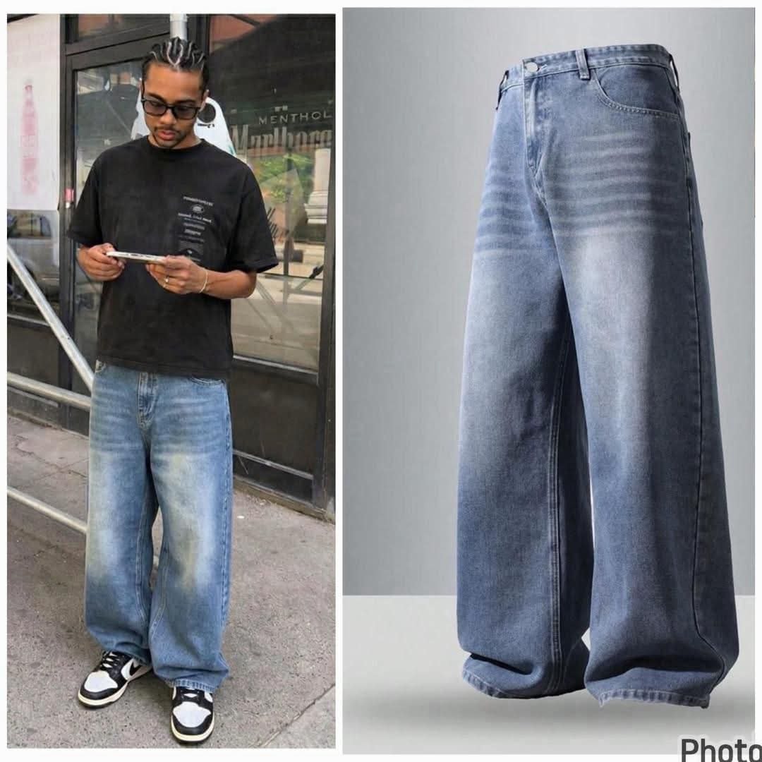 Man wearing light blue faded baggy jeans with black t-shirt, alongside back view flat lay.