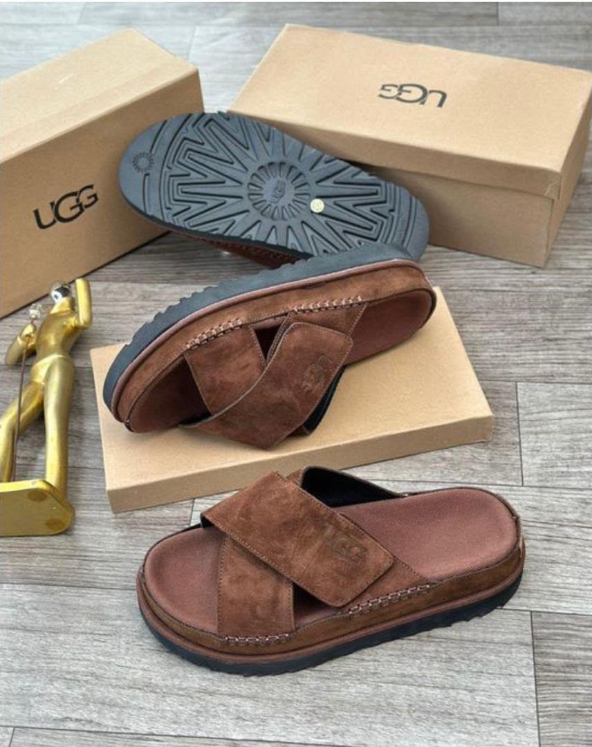 Brown UGG cross-strap sandals shown with box, sole view and gold figurine.
