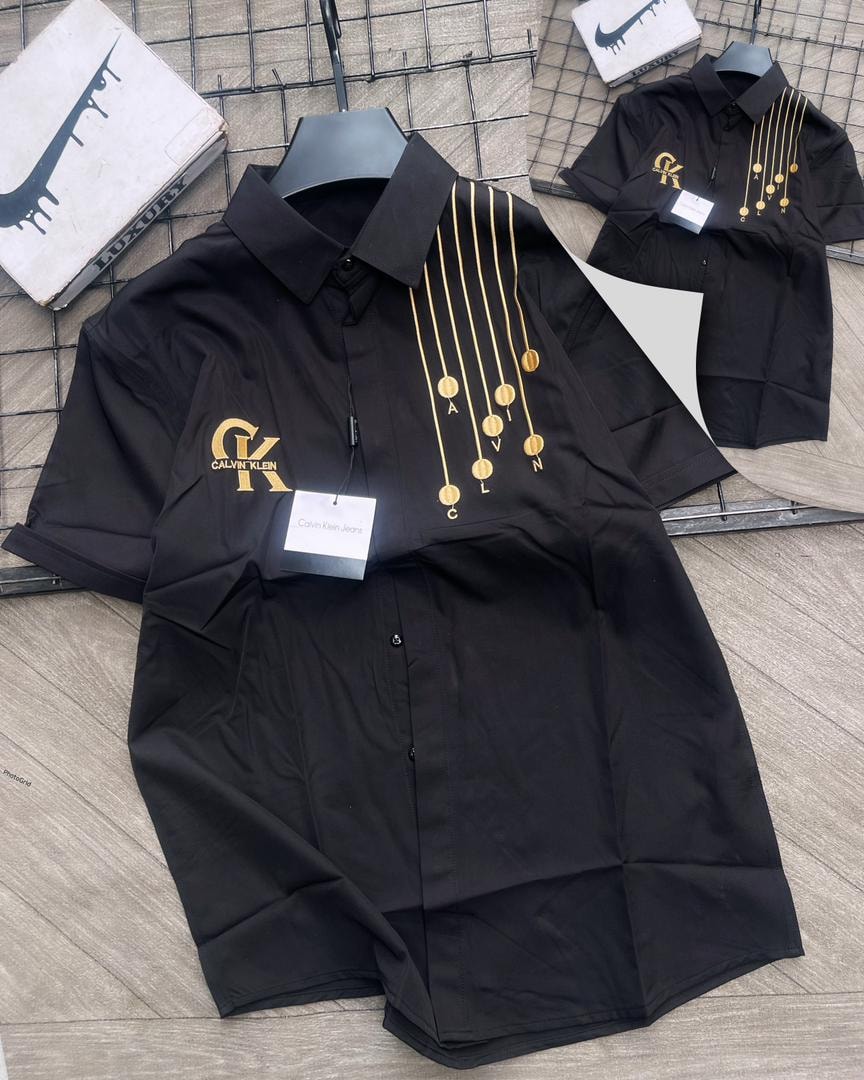 Black Calvin Klein short sleeve shirt with gold medallions.