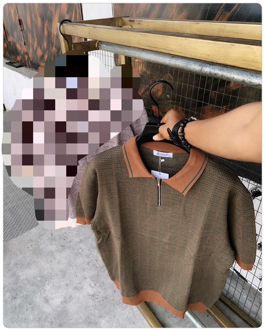 Brown geometric patterned knit polo shirt held on hanger.