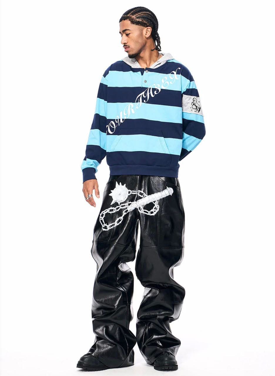 Full body view of model in blue striped hoodie with black leather pants.