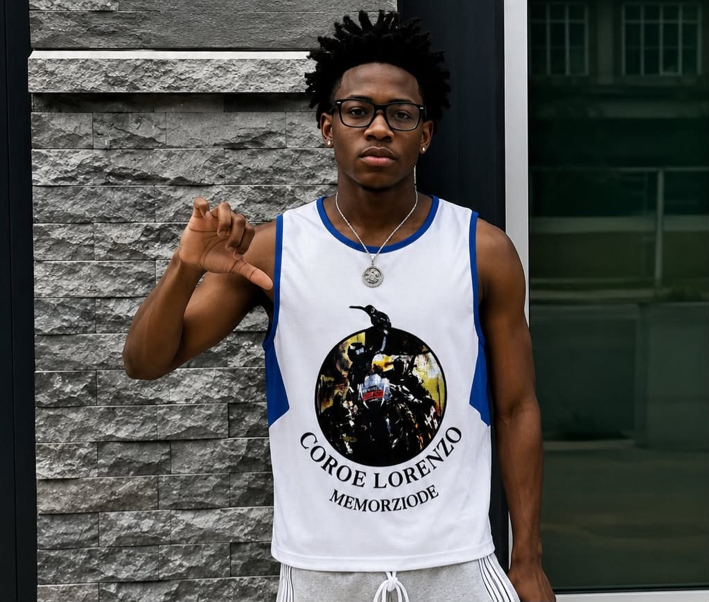 Man modeling white armless tank with blue side panels and circular motorcycle graphic.