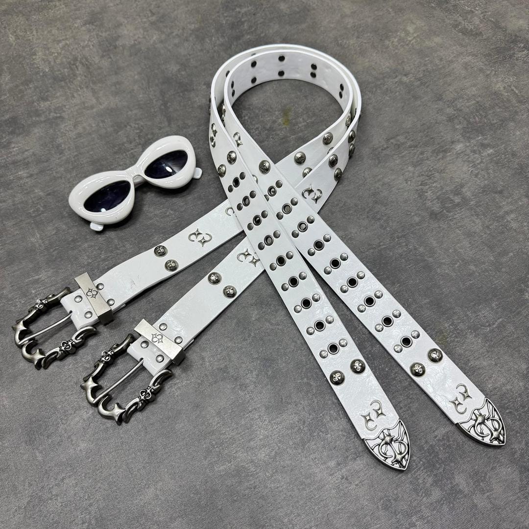 White ornate studded belt with metal details and white sunglasses on gray background.