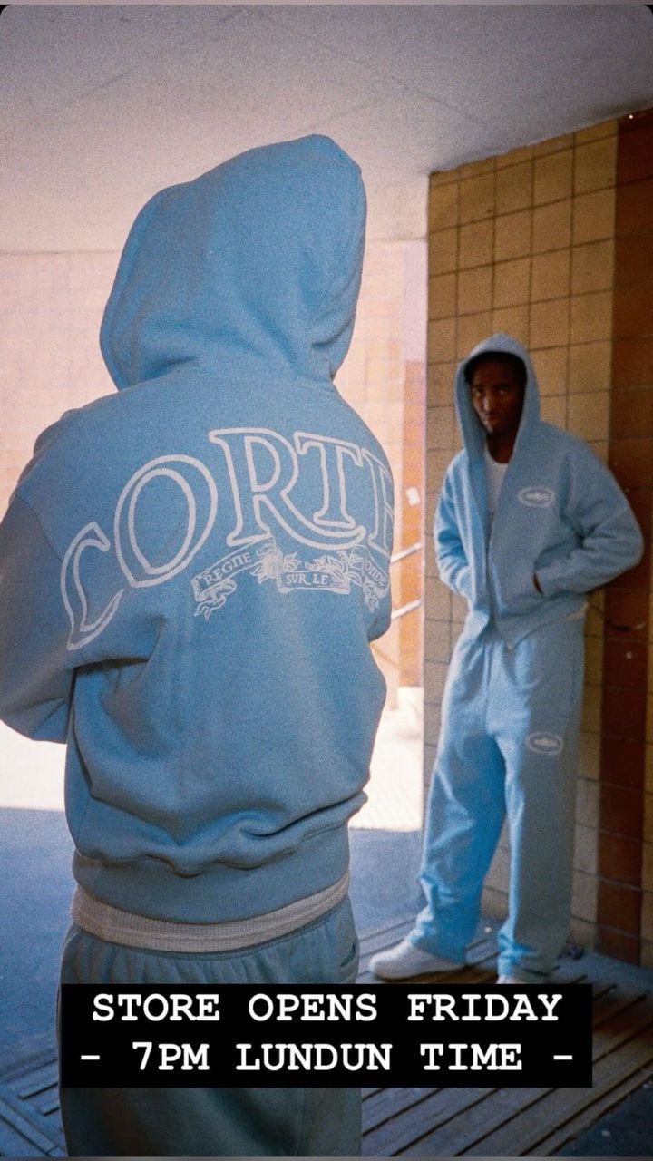 Model in light blue Corteiz zip-up hoodie and matching jogger pants.