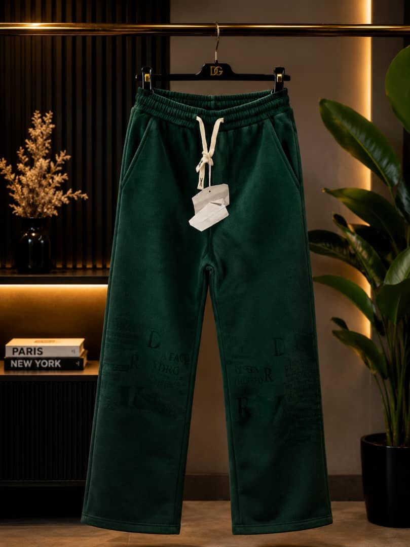 Olive green joggers with all-over faded text print.