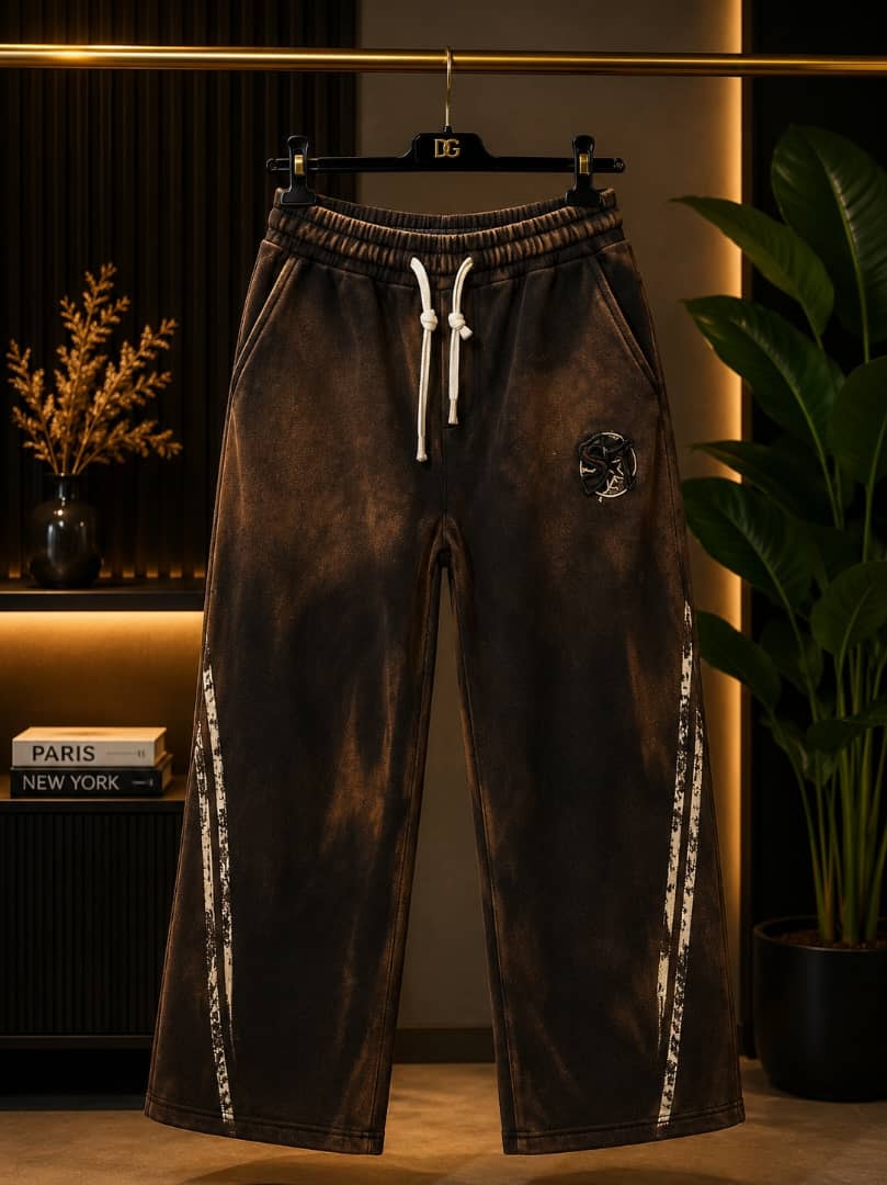 Brown acid wash joggers with white side stripes and circular emblem on thigh.