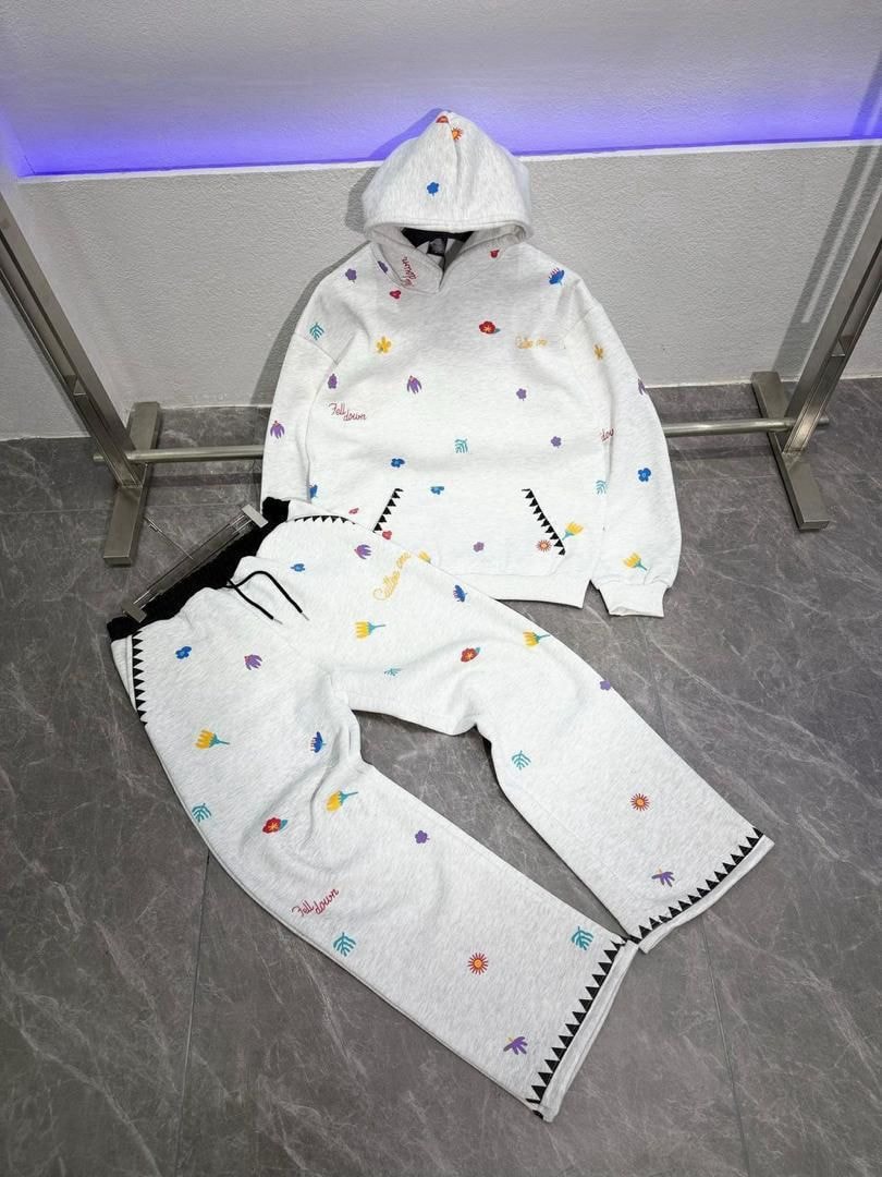 Flat lay of white all-over print floral hoodie and matching pants set on floor.