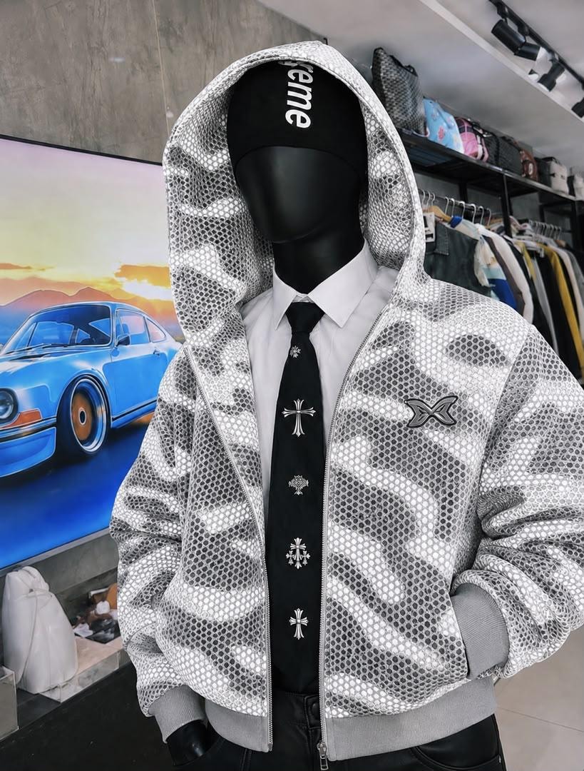 Mannequin wearing silver camo mesh cropped hooded jacket with zip front and chest logo.