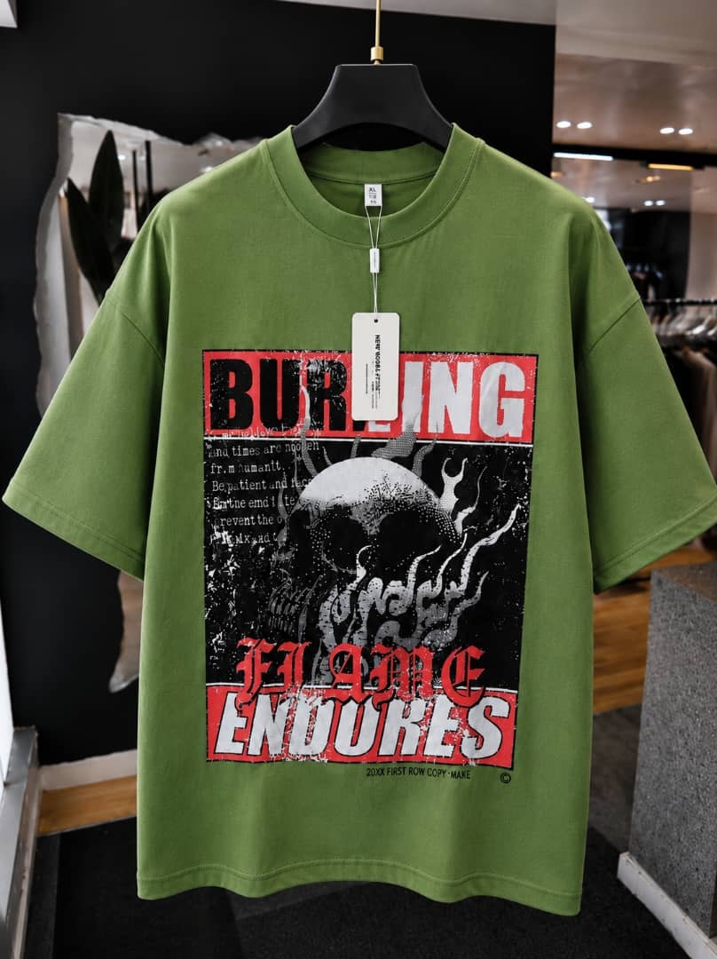 Green oversized t-shirt with burning flame endures skull graphic print.